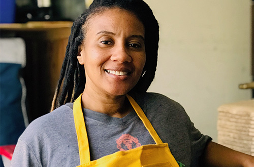 woman with braids wearing an apron over a t-shirt
