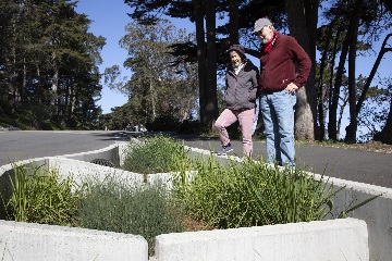 زوجان في منتصف العمر يراقبان البنية التحتية للمعهد الجغرافي على طول طريق عام