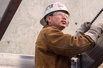 man wearing hardhat, goggles, and leather gloves