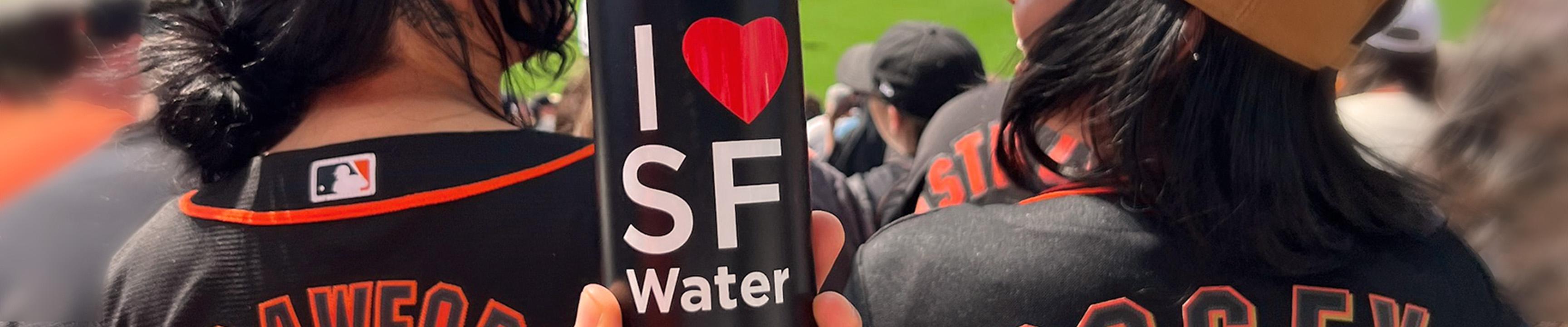 Fans enjoying the Giants game and a water bottle with I heart SF Water