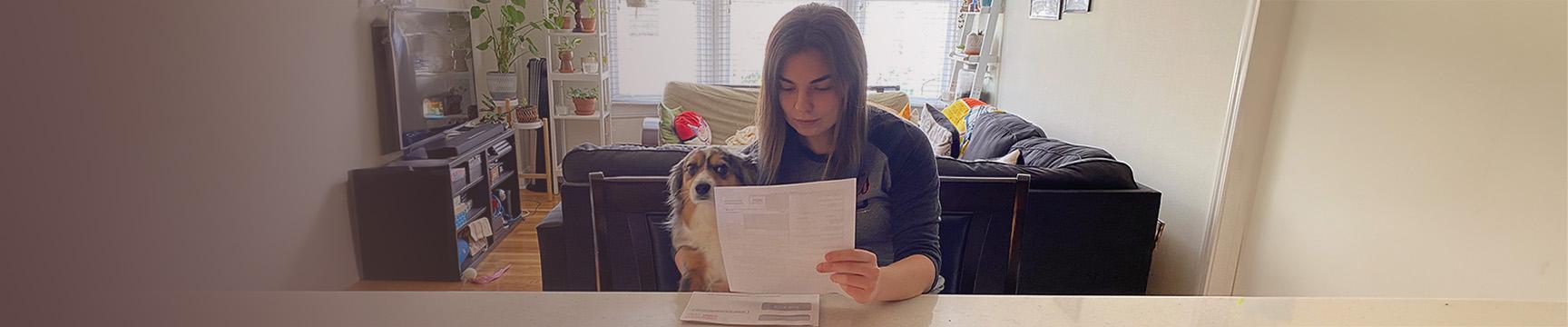 Mujeres con un perro leyendo su factura.