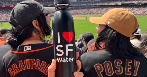 棒球比賽的兩名 SF 巨人隊球迷和前景中的 SF 水瓶。