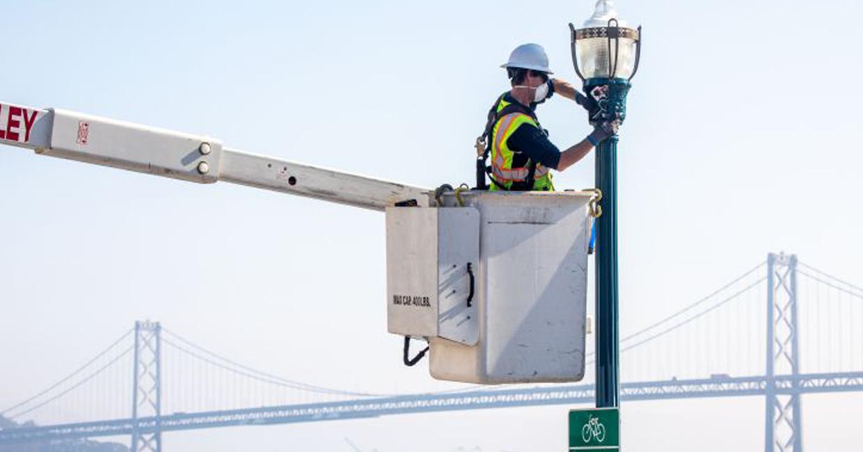 Nhân viên điều hành thay thế đèn đường bằng Cầu Bay trong nền