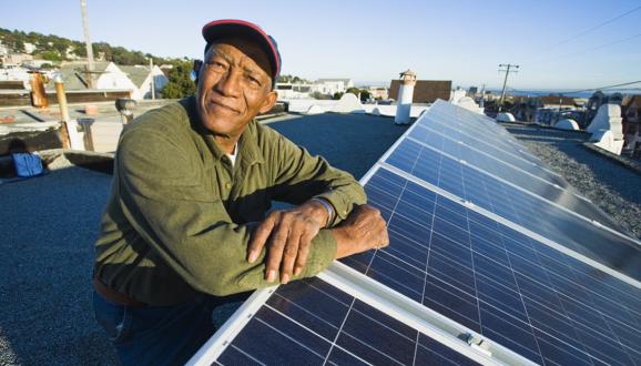 A man stands by a solar array.