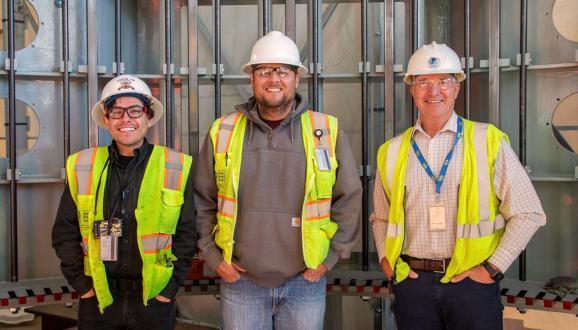 Đội Quản lý thi công đứng bên trong nhà máy thủy điện mới. Từ trái sang phải: Juan Barrios (Kỹ sư), Dustin Scholl (Kỹ sư thường trú SFPUC/Sinh viên thiết kế), Tim Parkan (Giám đốc dự án).