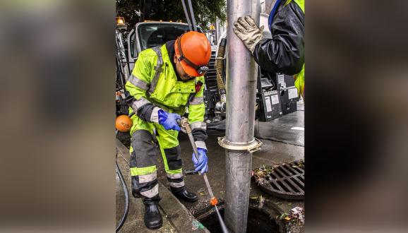 SFPUC worker cleaning a storm drain.