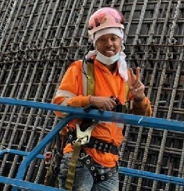 worker in safety harness giving the peace sign
